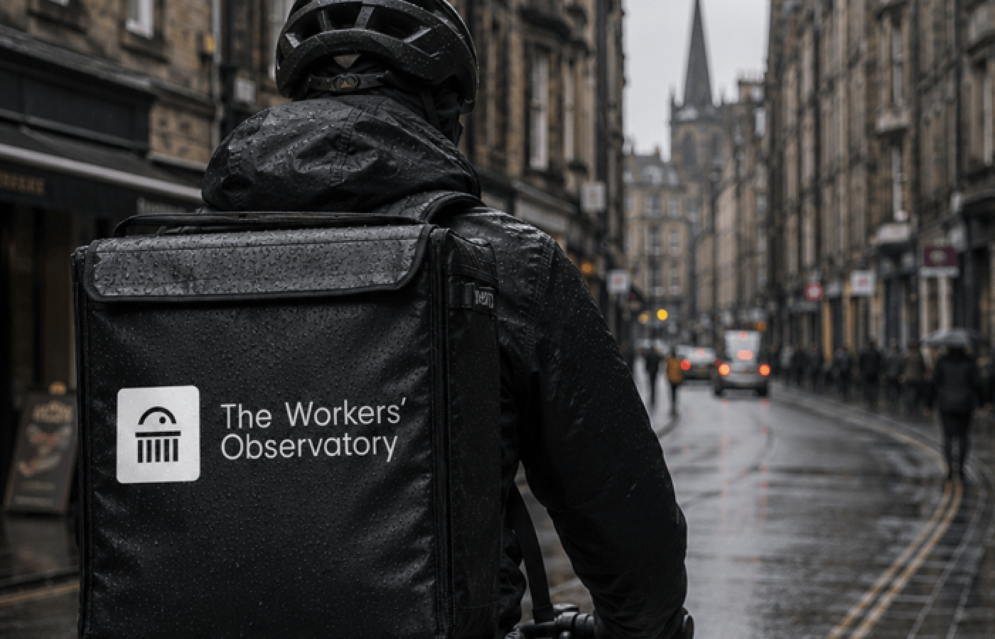 A delivery rider on a city street with a Workers' Observatory logo bag