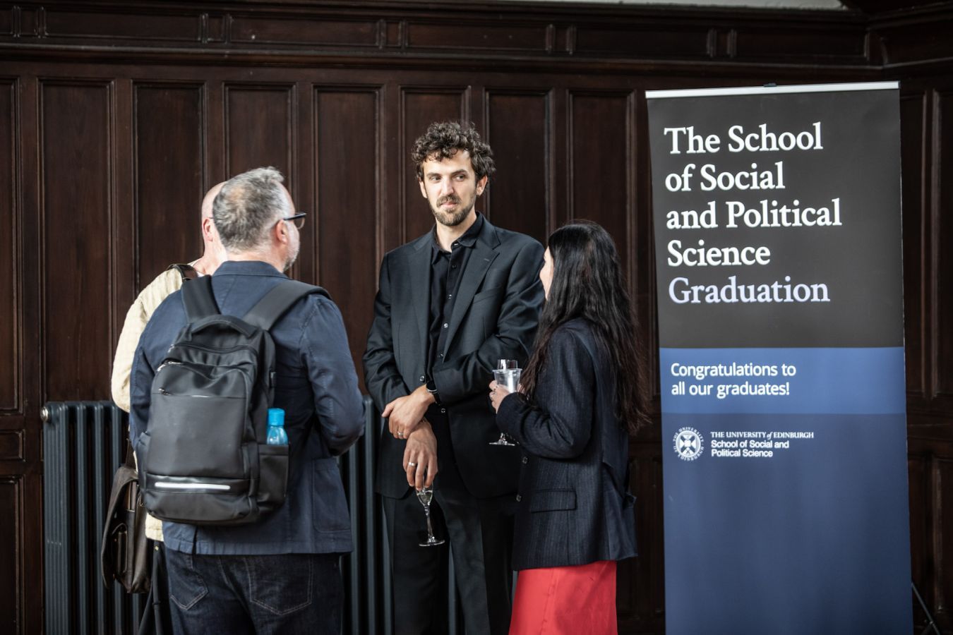 Students chatting next to SPS Graduations banner