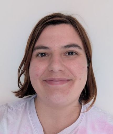 I am smiling at the camera, forward facing, in front of a white background.