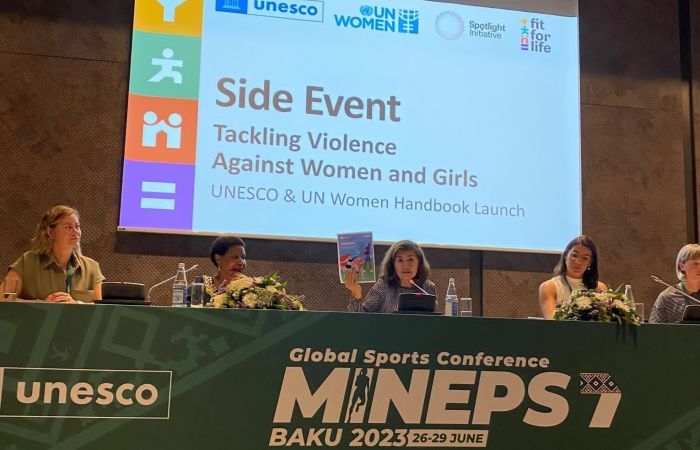 Emily Cameron-Blake and other panellists in front of a projector reading 'Tackling Violence Against Women and Girls'