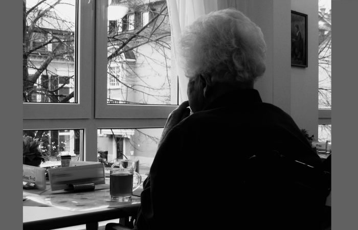 A promotional photo showing a person looking through a window