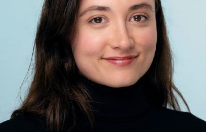 female-presenting, brown hair, brown eyes and a black turtleneck 